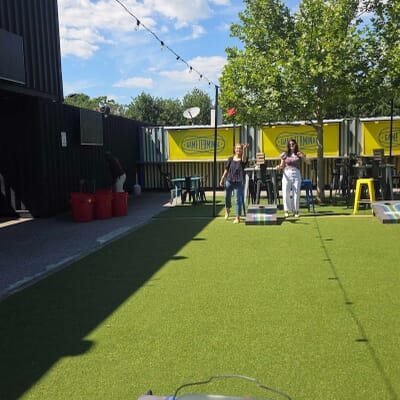 Maggie and Elizabeth playing a cornhole game during a team outing at Game Terminal in Nashville