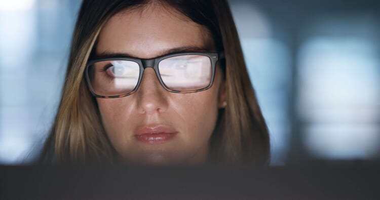 Woman with glasses reflecting computer screen