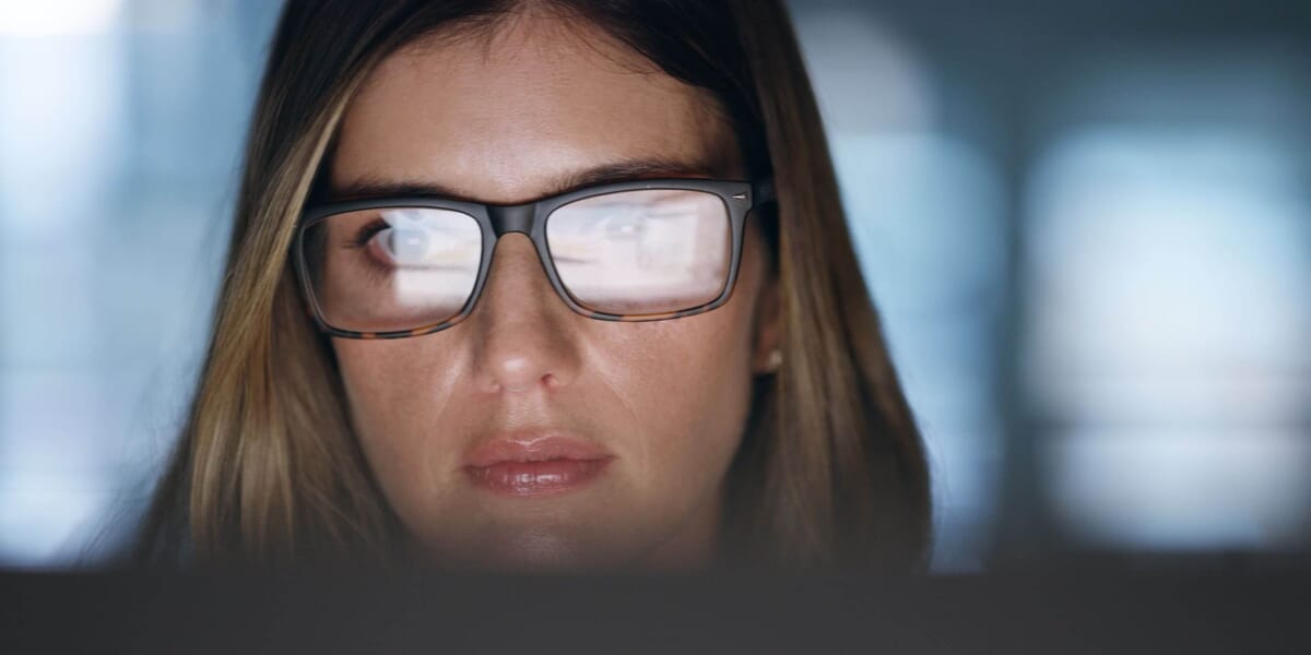 Woman with glasses reflecting computer screen