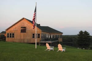 Spring Hill at sunsest with flag and adirondack chairs
