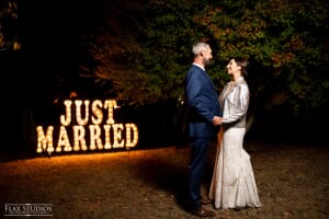 Bride and groom in front of Just Married lighted sign