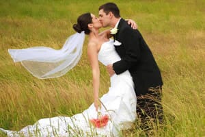 Beautiful bride and groom kissing in Maine meadow