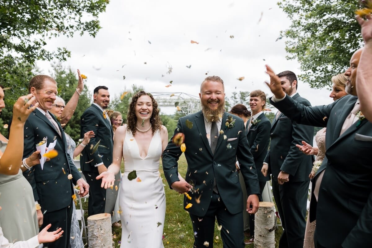 Maine newlyweds jumping after outdoor ceremony at Spring Hill in Maine