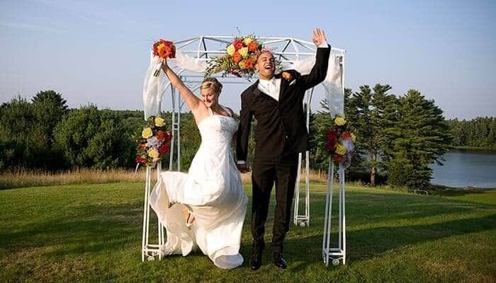 Maine newlyweds jumping after outdoor ceremony at Spring Hill in Maine