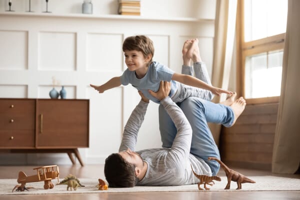 Father playing with son in living room